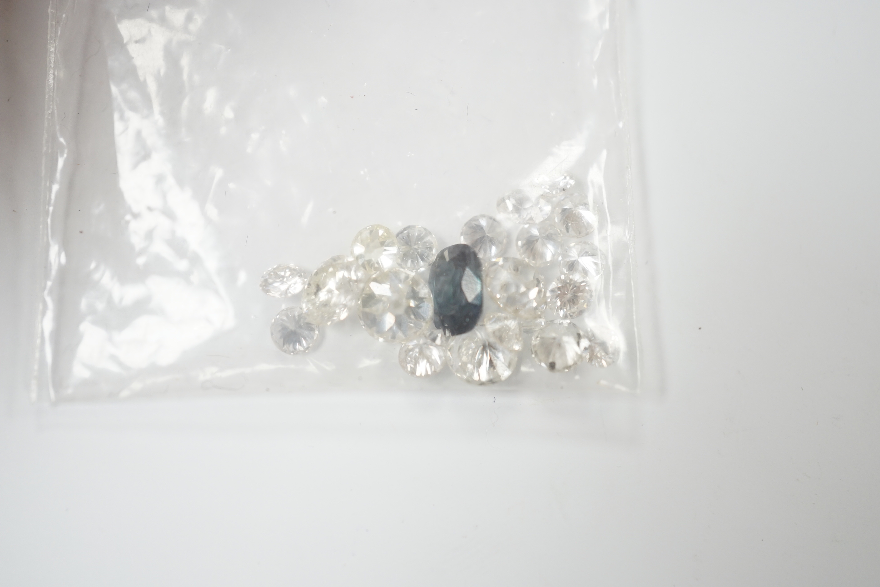 Twenty one unmounted cut diamonds, the four largest stones with an approximate total weight of 2.30ct, together with one unmounted cut sapphire.